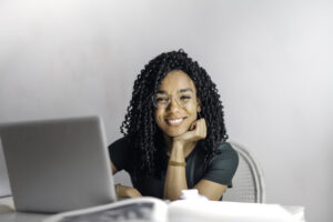 happy ethnic woman sitting at table with laptop 3769021 scaled