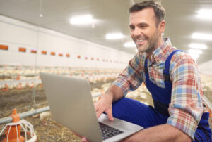 farmer using laptop in the farm business NQQUMHA scaled