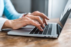 Local Banking in Columbia, Missouri | partial view of senior woman typing on laptop at home